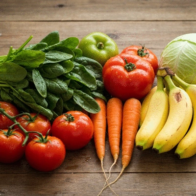 Fresh seasonal vegetables and fruits on a rustic wooden table, ready for cooking